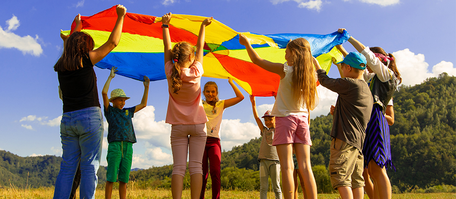 Children playing with a parachute at summer camp